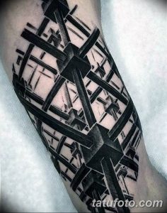 Фотография татуировки на руке, выполненной в стиле геометрической абстракции. Черные линии и фигуры создают сложный и динамичный рисунок.