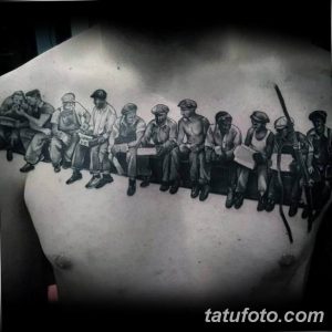 Фотография черно-белой татуировки на груди, изображающей группу рабочих, сидящих на балке. Детализированный рисунок в стиле реализм.