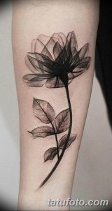 Фото тату: реалистичный рисунок цветка, выполненный в технике blackwork на предплечье, с детальной проработкой лепестков и листьев.