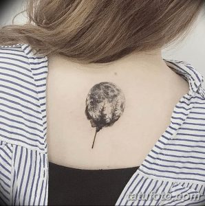Фото тату круглой луны с силуэтом леса внутри, расположенной на спине. Татуировка выполнена в технике black and grey.