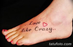 Фото тату с надписью "Love like Crazy" и сердечком на стопе. Черно-розовый рисунок, выполненный каллиграфическим шрифтом. Идеально для романтичных натур.