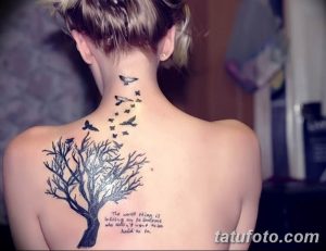 Фото тату с изображением дерева жизни, летящих птиц и вдохновляющей цитаты, выполненное в черном цвете.