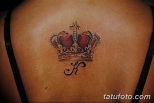 Фото тату короны с буквой на спине. Красивый рисунок татуировки с использованием красных и золотых оттенков.