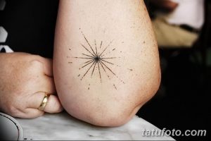Фото тату на локте: маленькая звезда, выполненная тонкими линиями и точками, минималистичный и стильный дизайн.