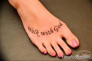 Фото тату на стопе: надпись "Walk with God" выполненная черным цветом, минималистичный и религиозный дизайн.