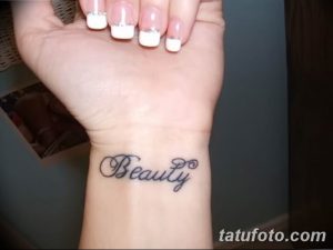 Фото тату на запястье: надпись 'Beauty' выполненная изящным шрифтом. Минималистичный рисунок татуировки для девушек.