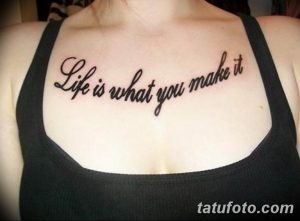 Фото тату надписи 'Life is what you make it' на груди девушки. Черный контур, каллиграфический шрифт, мотивационная татуировка.