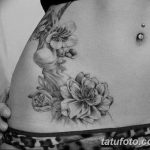 Фото тату на животе: нежные цветы сакуры и ветви, выполненные в технике blackwork. Красивый рисунок татуировки для девушек.