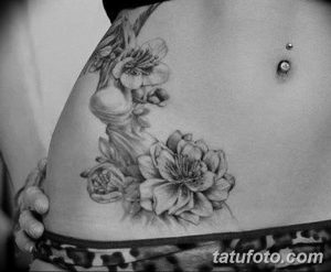 Фото тату на животе: нежные цветы сакуры и ветви, выполненные в технике blackwork. Красивый рисунок татуировки для девушек.