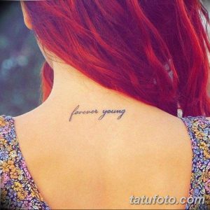 Фото тату надписи "forever young" на затылке, выполненной изящным шрифтом. Минималистичная и вдохновляющая татуировка.
