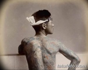 Фотография старинного изображения японского мужчины с татуировками Ирэзуми на спине. Изображение выполнено в сепии и демонстрирует традиционные мотивы.