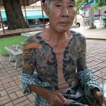 Фото тату японского стиля на предплечье мужчины, изображающее цветы, волны и традиционные японские узоры.