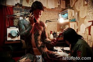 Фото мужчины, покрытого японскими татуировками в стиле Ирэзуми. Изображены драконы, волны, цветы и другие традиционные мотивы.