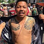 Фото тату на мужчине, демонстрирующее традиционный японский стиль Irezumi с изображением карпа кои и дракона на груди и руках.