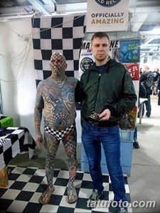 Фото тату: мужчина, полностью покрытый черно-белой шахматной татуировкой, стоит рядом с другим человеком.