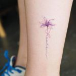 Фото тату стрекозы на ноге с надписью "Freedom". Минималистичный и изящный рисунок татуировки.