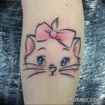 Фотография милой татуировки на руке, изображающей котенка с бантиком. Изображение демонстрирует очаровательный и нежный дизайн татуировки.