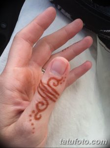 Фото тату хной на пальце, выполненное в минималистичном стиле с использованием тонких линий и точек. Идеально для тех, кто ценит лаконичность.