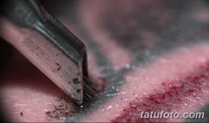 Фото тату: крупный план тату-машинки, работающей над кожей. Видны контуры рисунка и процесс нанесения пигмента.