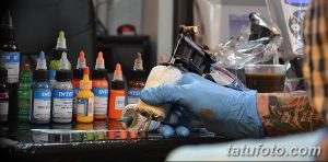 Фото тату: разноцветные чернила для татуировок, тату-машинка и другие инструменты, необходимые для создания рисунка татуировки.