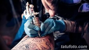 Фото процесса создания татуировки: мастер наносит контуры татуировки на руку клиента, используя тату-машинку.