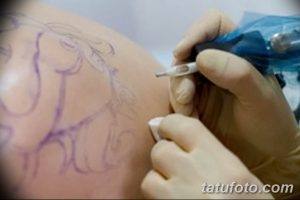 Фото процесса создания татуировки: мастер наносит контурный эскиз на спину клиента, используя маркер.