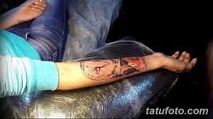 Фото тату процесса: рука клиента с яркой, незавершенной татуировкой, покрытая защитной пленкой. Видны красочные мазки краски.