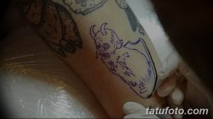 Фото эскиза татуировки с изображением головы демона. Рисунок выполнен в черно-белом цвете, с акцентом на детализацию и зловещий взгляд.