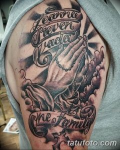 Фото тату на предплечье: сложенные в молитве руки с четками, надпись 'Heaven Forever', розы и текст 'One Family'. Черно-серый рисунок.