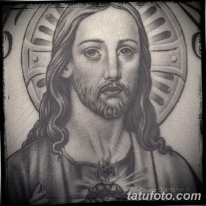 Фото тату Иисуса Христа в стиле blackwork. Черно-белый рисунок с детальной проработкой лица и нимба, выполненный в графической технике.