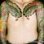 Фото тату двух драконов на груди мужчины, выполненное в ярких цветах с использованием традиционных японских мотивов.