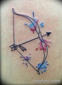 Фото тату: Акварельная татуировка с изображением лука и стрелы, выполненная в нежных пастельных тонах с брызгами краски.