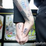 Фото тату на пальцах рук с надписями 'LV' и 'RIG', выполненными черными чернилами. Минималистичный и символичный дизайн для пары.