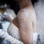 Фото тату: изысканная белая татуировка в виде кружева на плече невесты. Нежный и элегантный рисунок татуировки, имитирующий кружевное платье.
