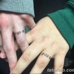 Фотография двух рук с парными татуировками в виде даты. Татуировки выполнены в черном цвете и имеют простой дизайн.