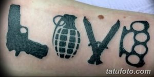 Фото тату: Необычная татуировка на предплечье, где буквы слова 'Love' образованы изображениями пистолета, гранаты, ножей и кастетов. Рисунок татуировки.