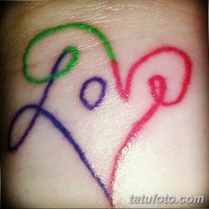 Фото тату надписи 'Love', выполненной в разных цветах. Необычный и креативный рисунок татуировки на руке.