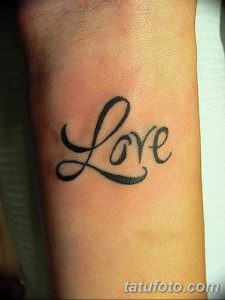 Фото тату надписи 'Love', выполненной изящным шрифтом на запястье. Минималистичный и стильный рисунок татуировки.