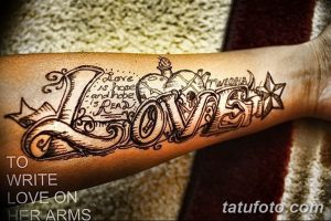 Фото тату на предплечье: большая надпись 'Love' в винтажном стиле с декоративными элементами.