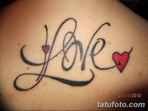 Фотография татуировки на спине, изображающей слово 'Love' с сердечками вместо букв 'o'. Черно-красный рисунок татуировки.
