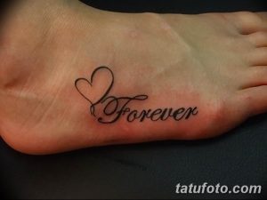 Фото тату на стопе с надписью 'Forever' и изображением сердца, выполненного тонкими линиями.