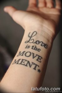 Фото тату на запястье с надписью 'Love is the Movement' выполненной каллиграфическим шрифтом.
