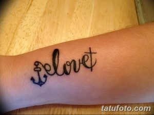 Фото тату надписи 'I love' с изображением якоря на запястье. Черный цвет, классический стиль, морская тематика.