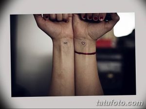 Фото парных тату на запястьях: на одном запястье символ бесконечности, на другом - маленькое сердце. Черный цвет, тонкие линии.