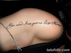 Фото тату надписи 'You and I are gonna Live Forever' черным цветом на лопатке. Изящный шрифт, подчеркивающий красоту линий.