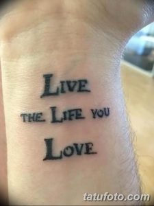 Фото тату надписи "Live the life you love" черным шрифтом, расположенной на руке. Простая, но вдохновляющая татуировка с позитивным посылом.
