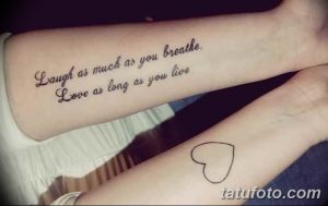 Фото татуировки надписью 'Laugh as much as you breathe. Love as long as you live' на предплечье и запястье. Красивый каллиграфический шрифт.