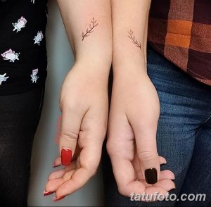 Фото парных татуировок на запястьях с изображением тонких веточек с листьями, символизирующих связь с природой и гармонию.