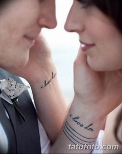 Фото тату с надписями 'I love him' и 'I love her' на запястьях пары, символизирующее вечную любовь и преданность.