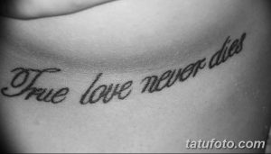 Фото татуировки на теле: черная надпись 'True love never dies' (Истинная любовь никогда не умрет). Минималистичный дизайн.